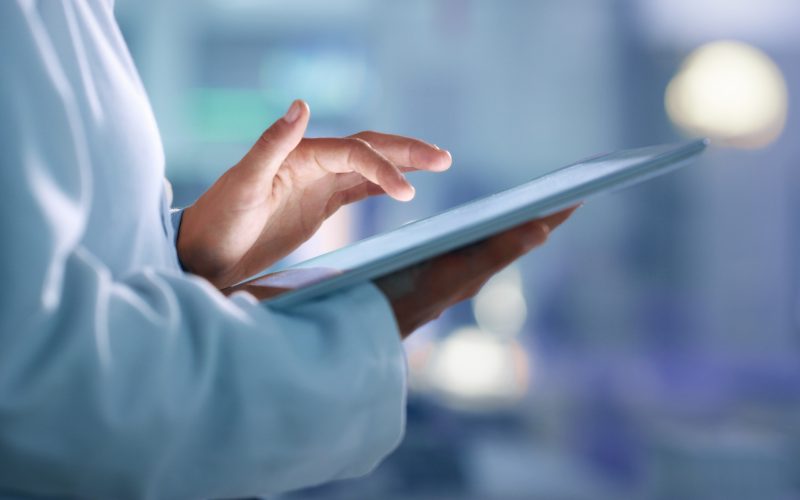 Doctor, researcher or scientist browsing the internet on a tablet for information while working at a lab, science facility or hospital. Expert, medical professional or surgeon searching the internet